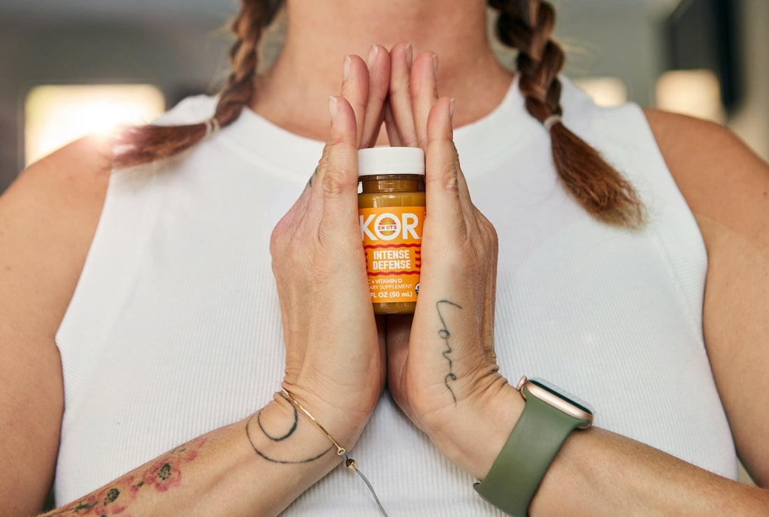 woman in white tank top holding an intense defense kor shot