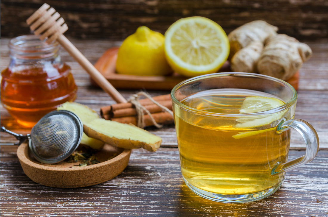 fresh natural ginger herbal tea in a glass cup on wooden table