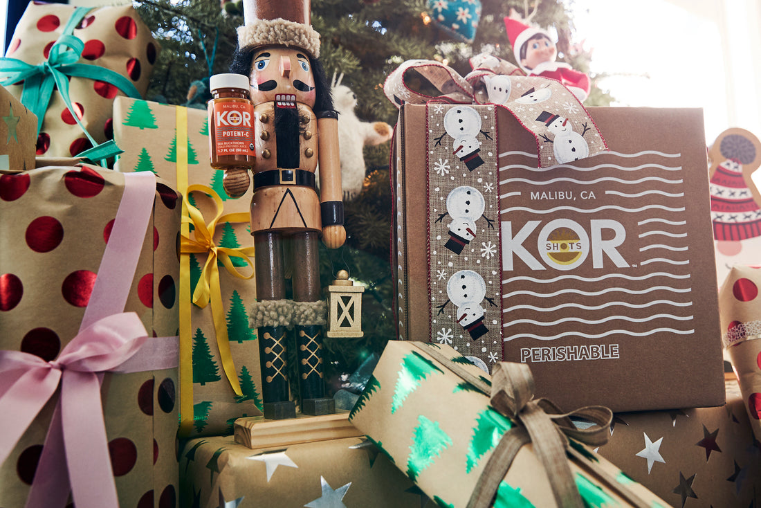 nutcracker under a Christmas tree with a kor shots shipping box 