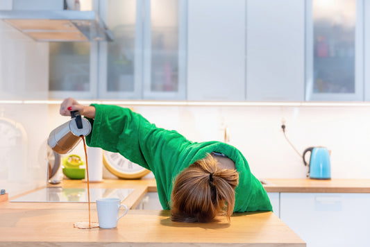 Tired woman sleeping on the table in the kitchen at breakfast